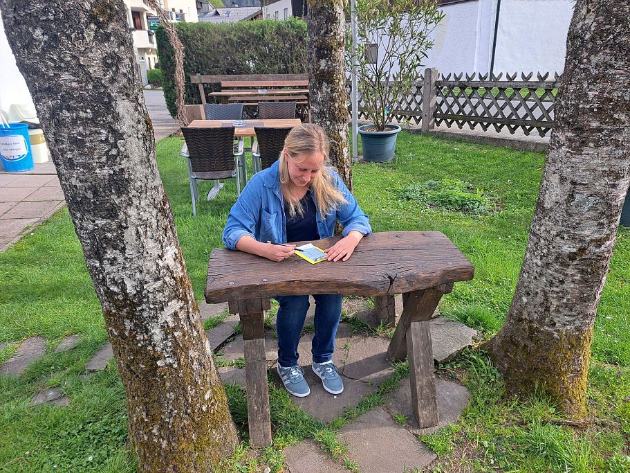 Frau sitz auf einer Bank und berechnet Punkte beim Minigolf